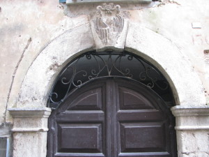 57 via Nazario Sauto - portone con Monogramma della Vergine in ferro battuto e s